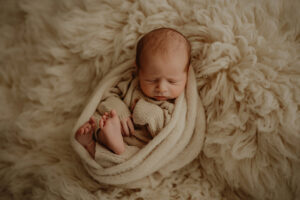 newborn baby boy on tan rug in york pa newborn photography studio